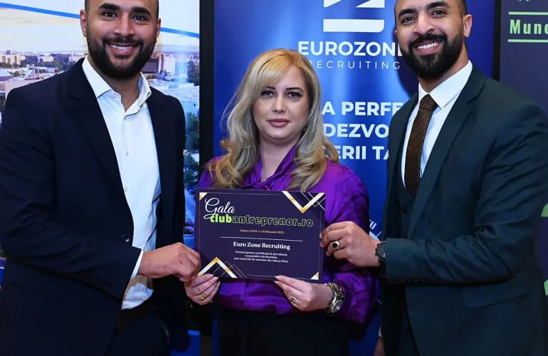 Three colleagues holding the Gala Clubantreprenor certificate made out to Euro Zone Recruiting, in front of the company banner.